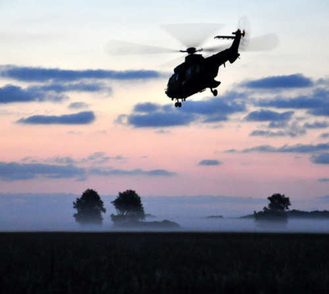 Silhouette van helikopter tegen zonsopgang