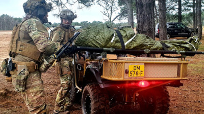 Militairen vervoeren slachtoffer op een quad